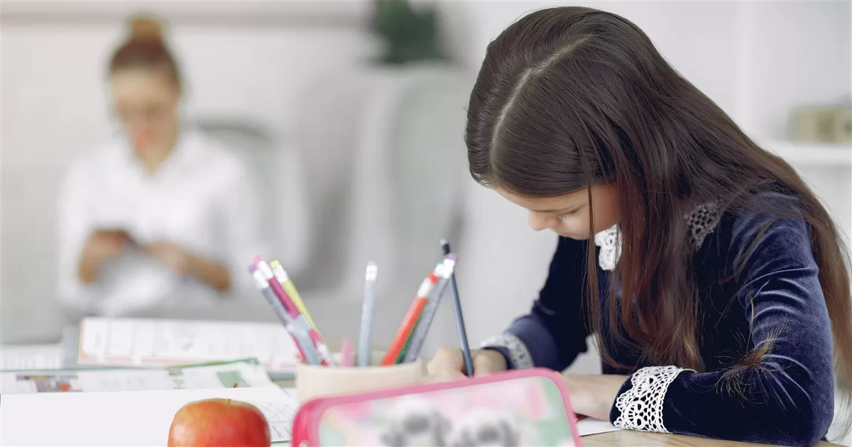 Menina a estudar em casa com a mãe por perto: homeschooling NEE Portugal